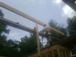 Carpenter setting a ridge beam over a new addition frame — Ice Dam Removal by Roofing Brothers in Barkhamsted