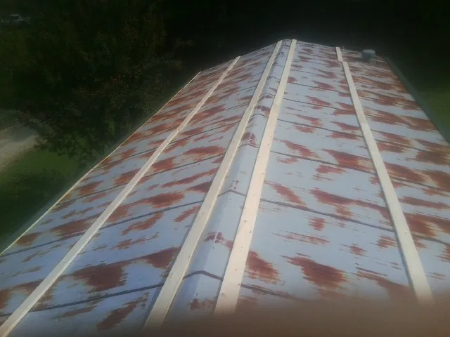 Rusted metal roof panels with new wood purlins before replacement — Storm Damage Roof Repair in Barkhamsted by Roofing Brothers