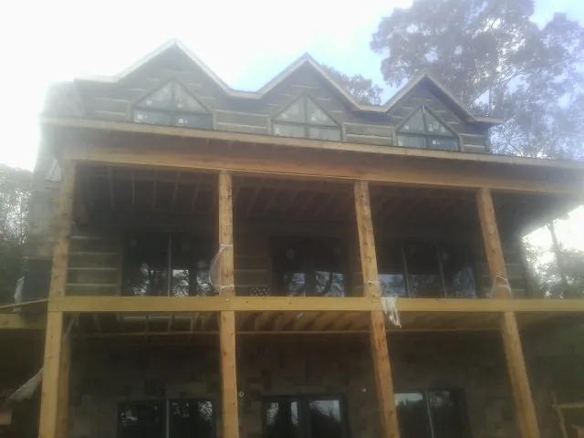 Dormers and porch framing on a large log home under construction — Roof Coating work by our crew in Barkhamsted