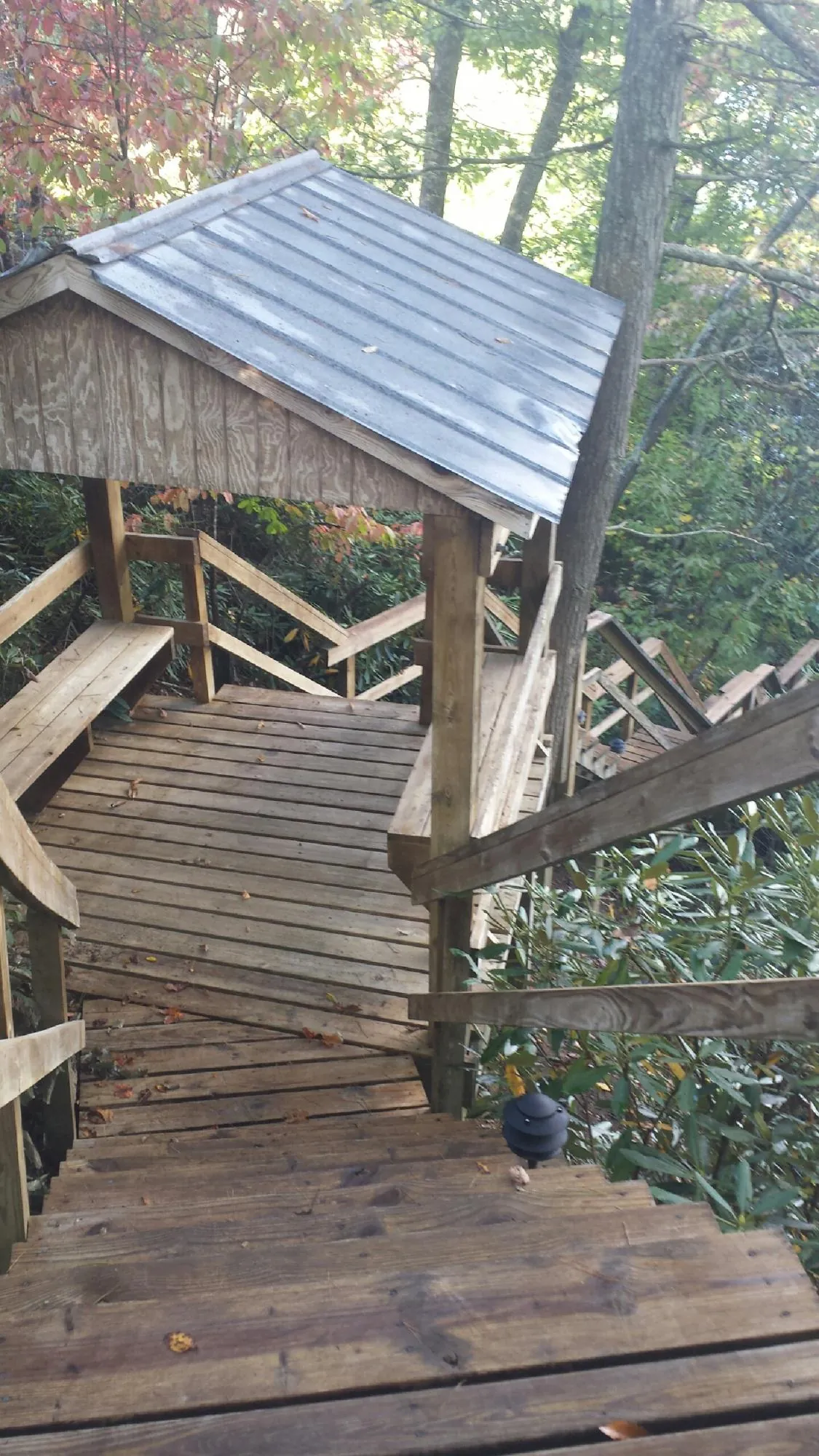 Metal roofed shelter over wooden steps on a wooded walkway — Skylight Repair & Installation work by our crew in Barkhamsted
