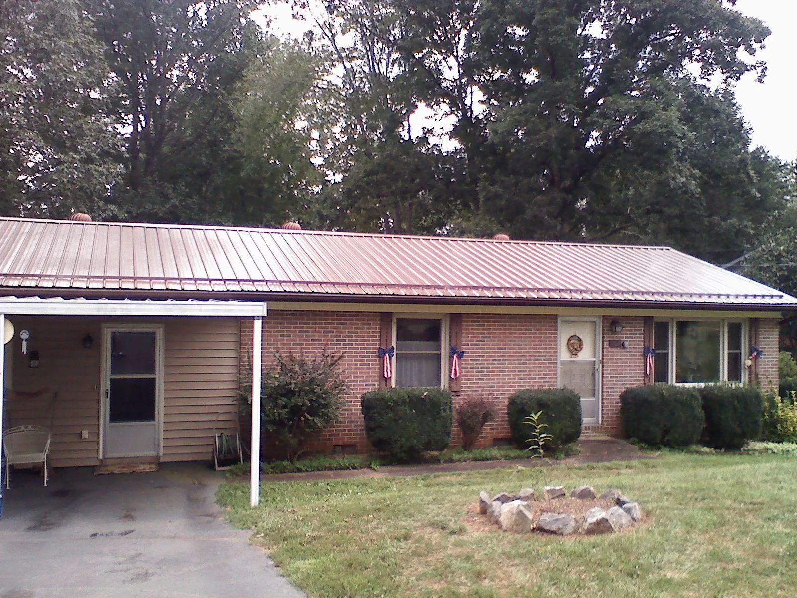 Bronze metal roof and carport on a brick ranch home — Roof Repair work by our crew in Barkhamsted
